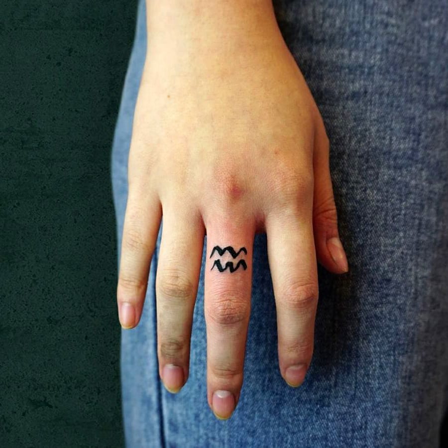 Wave symbol tattoo on finger