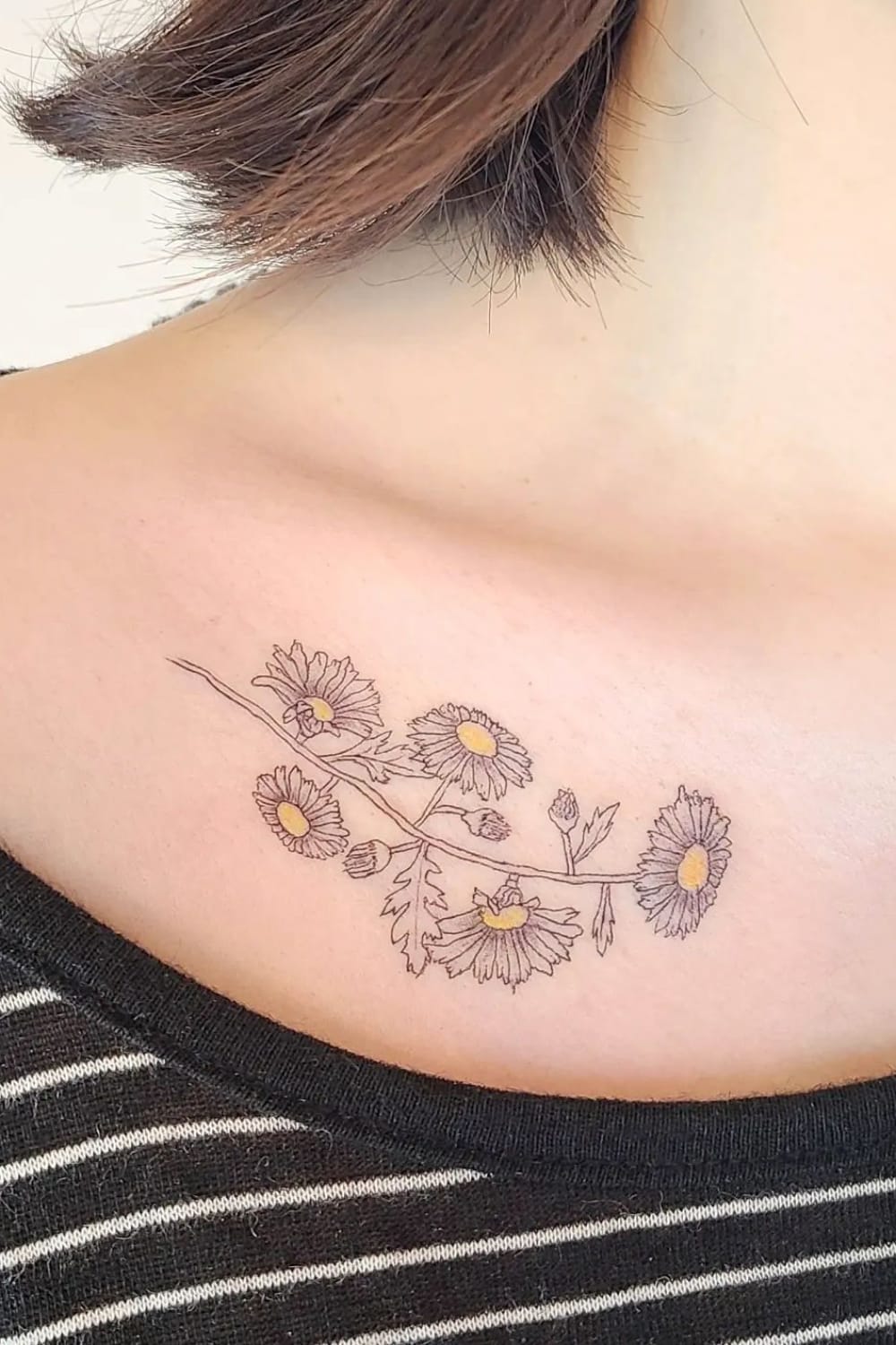 Daisy tattoo on collarbone