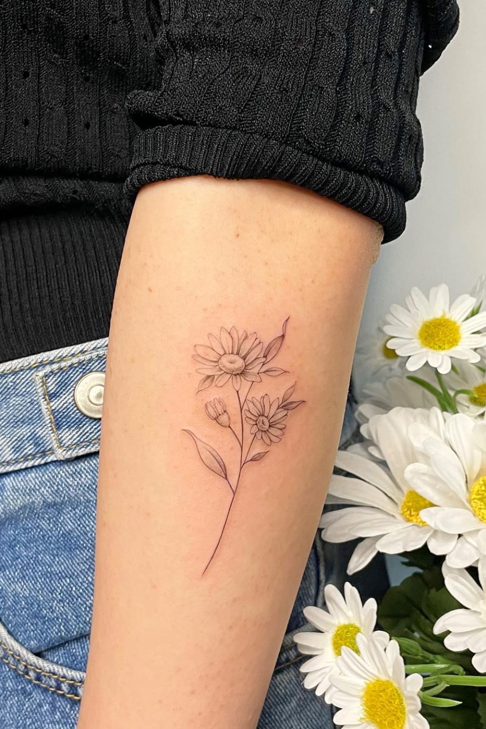 Daisy tattoo on forearm