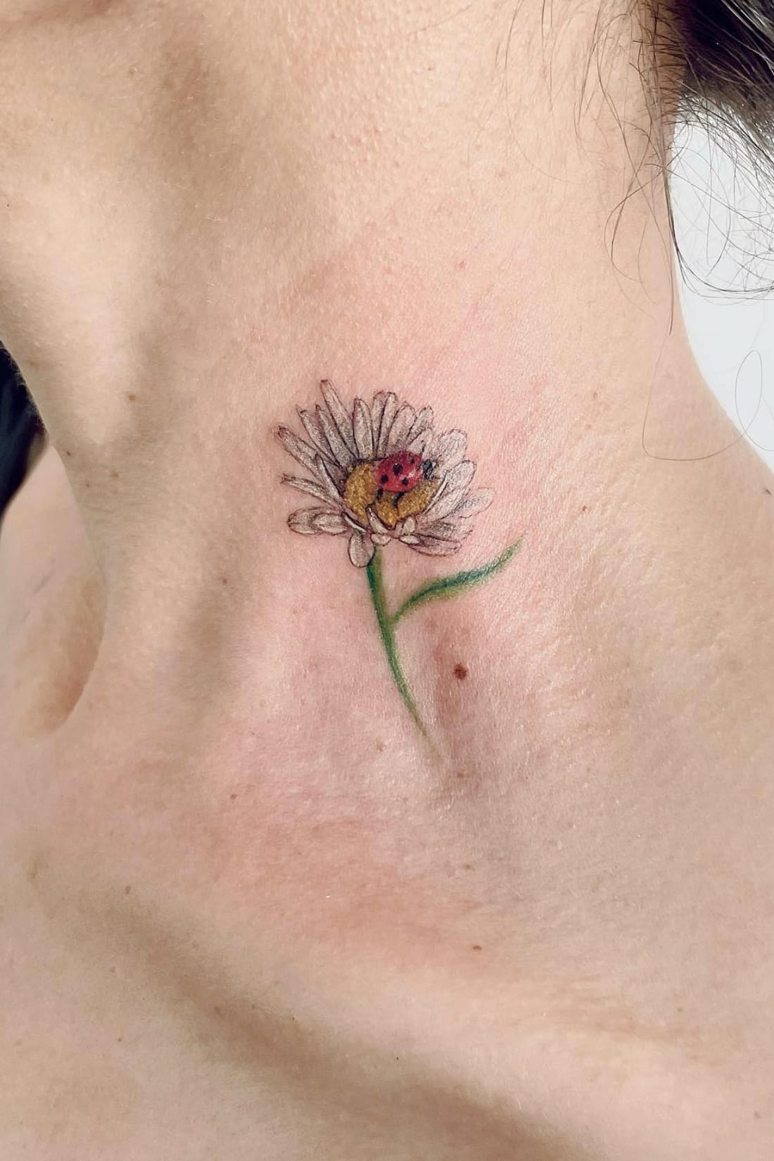 Daisy tattoo on neck